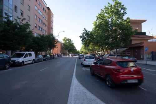 a red car is driving down a city street at Hotel Villa de Barajas in Madrid