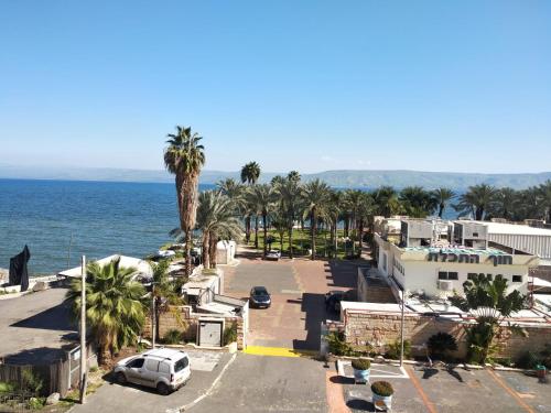 a street in a town with palm trees and the ocean at Apartment By The Lake in Tiberias