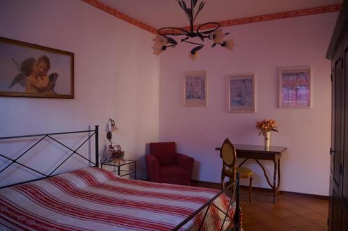 a bedroom with a bed and a chair and a desk at Dimora tipica toscana in Montecatini Val di Cecina