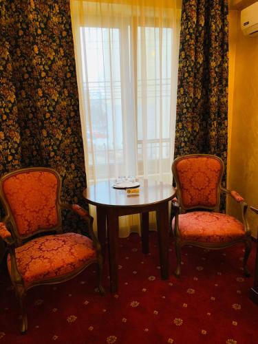 a room with a table and two chairs and a window at Vila Royal in Bacău