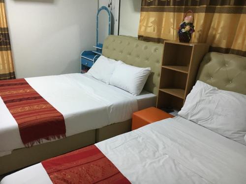 two beds in a small room with two beds at บุญจินดา รีสอร์ท in Ban Phayom