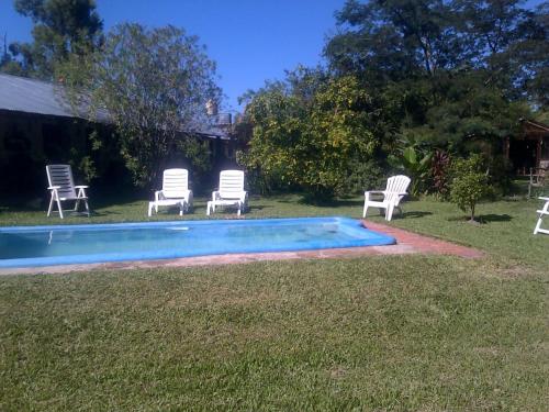 un grupo de sillas sentadas alrededor de una piscina en Hospedaje San Cayetano en Colonia Carlos Pellegrini