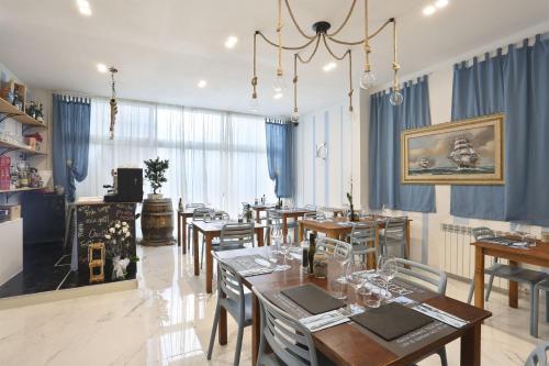 a dining room with tables and chairs and blue curtains at Hotel Nuovo Tirreno in Lido di Camaiore