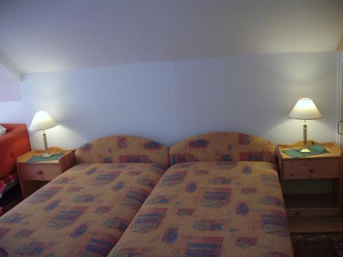 a hotel room with a bed and two lamps on tables at Apart Hévízi Ház in Hévíz