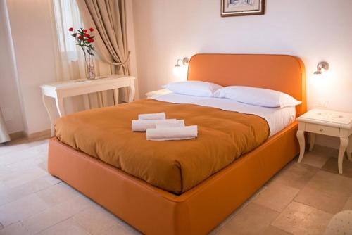 a large orange bed with two towels on it at Agriturismo I Pozzetti in Savelletri di Fasano