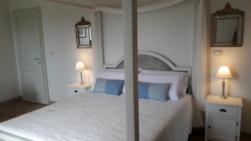 a bedroom with a white bed with blue pillows at B&B Cum Grano Salis in Castello delle Forme