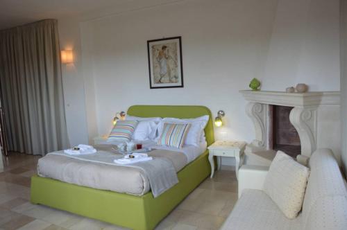 a bedroom with a green bed and a chair at Agriturismo I Pozzetti in Savelletri di Fasano