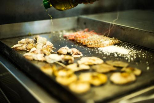 a grill with some pizza and shrimp on it at Miami Mar - Boutique Hotel & Restaurante in Sant Carles de la Ràpita