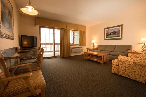 a living room with a couch and a tv at Lakeside Lodge and Suites in Chelan