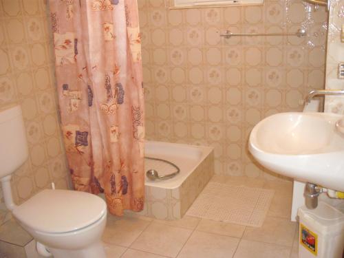 a bathroom with a toilet and a sink and a tub at Apart Hévízi Ház in Hévíz