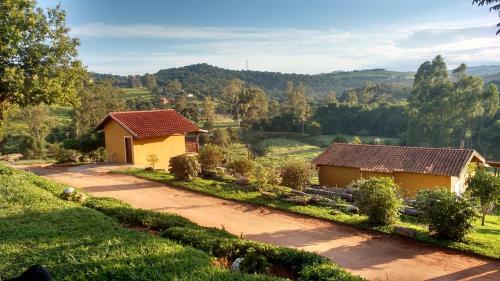 a view of two small houses in a field at Pousada e Camping Pé na Trilha in Bueno Brandão