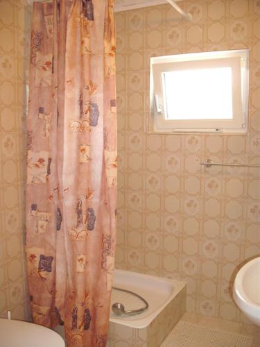 a bathroom with a shower curtain and a sink at Apart Hévízi Ház in Hévíz