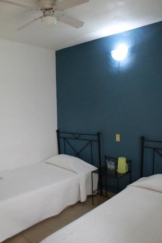 a room with two beds and a blue wall at Hotel Casablanca Tuxtla in Tuxtla Gutiérrez