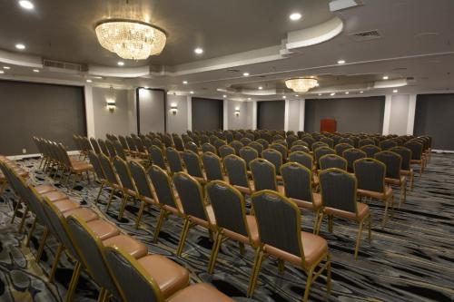 a conference room with rows of chairs and a stage at Adria Hotel and Conference Center in Queens