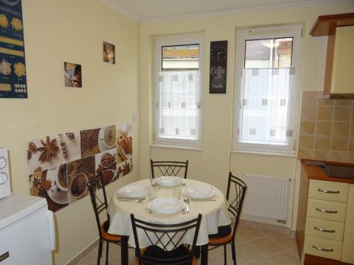 une salle à manger avec une table et des chaises dans une cuisine dans l'établissement Teleki Apartman Kaposvár, à Kaposvár