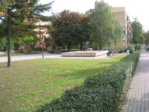 a hedge in a park next to a building at Startpont Apartman in Pécs