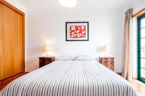 a bedroom with a large bed with two night stands at Apartamento Parque Ria Formosa, Olhão in Olhão