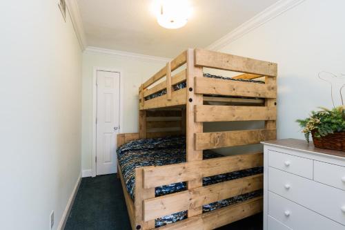 a bedroom with a bunk bed with a wooden ladder at Sands Beach Club in Myrtle Beach