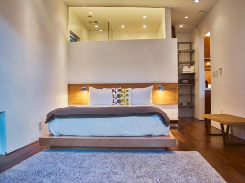 - une chambre avec un grand lit et un tapis dans l'établissement Cactus Flower, à Los Angeles