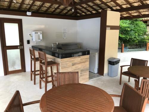 a patio with a table and chairs and a kitchen at Porto Praia do Forte in Praia do Forte