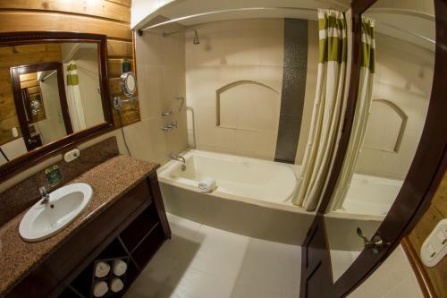 a bathroom with a tub and a sink and a toilet at Baldi Hot Springs Hotel & Spa in Fortuna