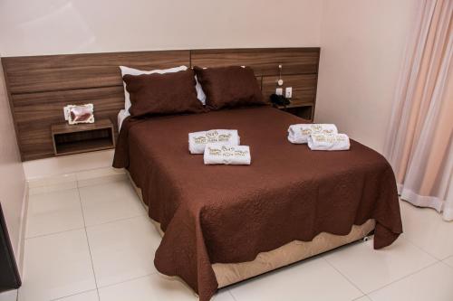 a bedroom with a large bed with towels on it at SERPYL Plaza Hotel in Encarnación