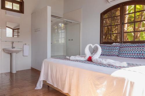 a bed with two towels in the shape of hearts at Pousada Toca do Mar in Praia de Palmas