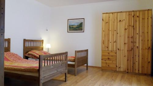 um quarto com 2 camas e um armário de madeira em Sváb Ház em Veszprémfajsz