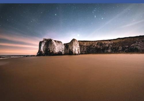 a view of a rock formation on a beach at night at Nest Guesthouse in Margate
