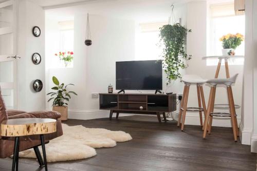 a living room with a flat screen tv on a table at Silver View-Spa Hot Tub-Beautiful Sea Views-Free Parking- Central Lyme Regis in Lyme Regis