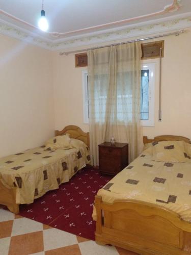 a bedroom with two beds and a window at Apartamento El Mirador in M'diq