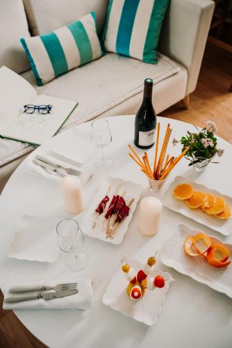 a white table with wine glasses and food on it at Les Jardins du Phare de Sidi Bou Said in Sidi Bou Saïd