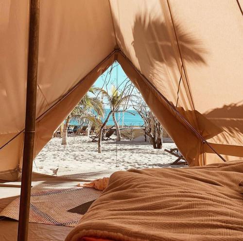 a person laying on a bed under an umbrella at ChiloChill Glamping Resort in La Ventana