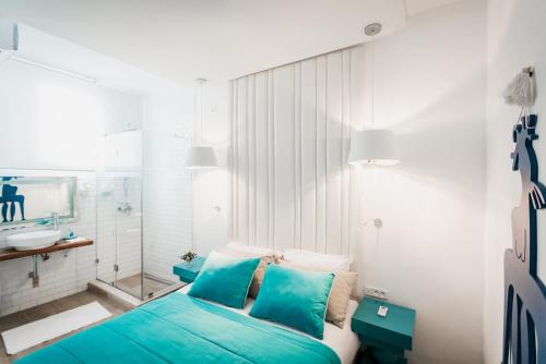 a bedroom with a blue bed and a sink at Les Jardins du Phare de Sidi Bou Said in Sidi Bou Saïd