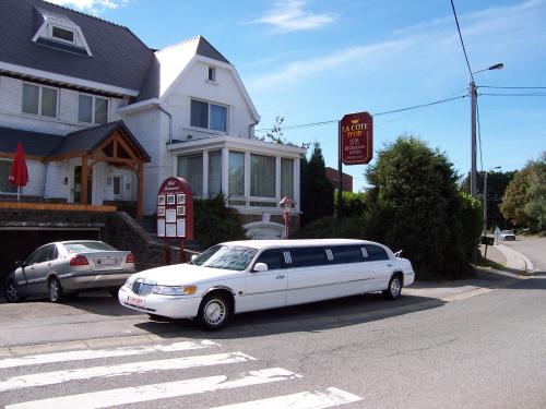 a white limo parked in front of a house at Hôtel La Côte d'Or in Philippeville