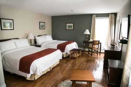 a hotel room with two beds and a table at The Harbour House in Charlottetown