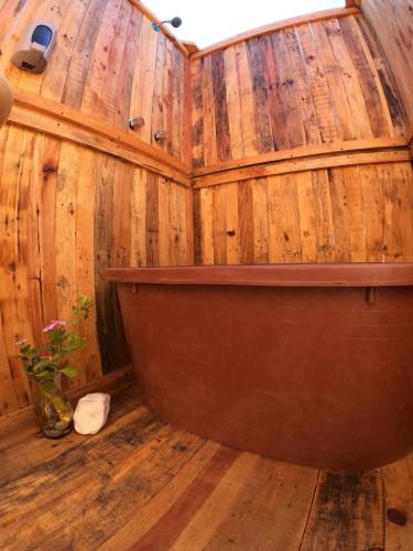 a wooden bathroom with a tub in a wooden wall at ChiloChill Glamping Resort in La Ventana