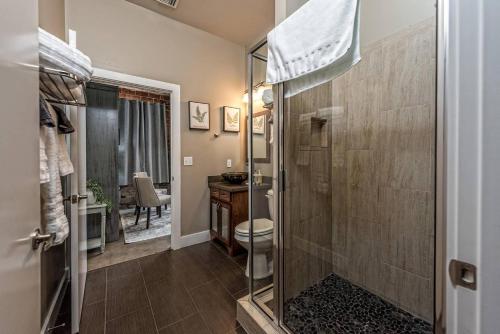 baño con ducha y aseo y escritorio. en Green Door Lofts -Magnolia Loft, Silos/Downtown en Waco