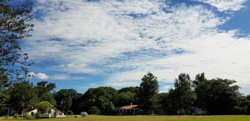 a field with trees and a cloudy sky at Posada El Prado in Salta