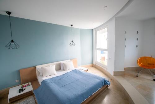 1 dormitorio con cama y pared azul en The View Gammarth en Gammarth