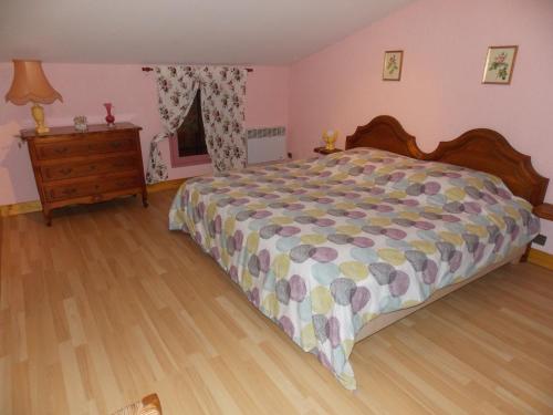 1 dormitorio con 1 cama grande y suelo de madera en Gîte l'Antre Vous en Saint-Philippe-dʼAiguille
