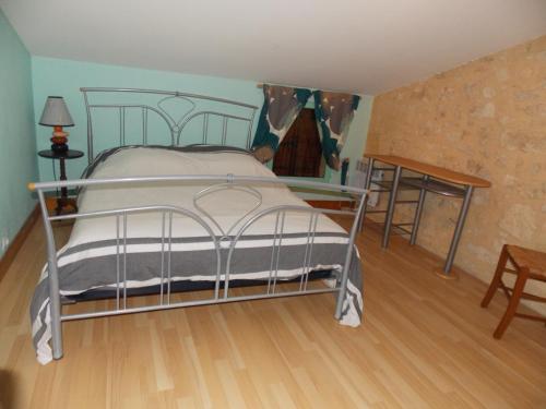 1 dormitorio con 1 cama de metal en una habitación en Gîte l'Antre Vous en Saint-Philippe-dʼAiguille