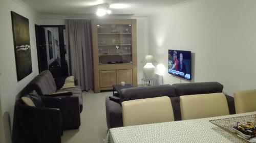 ein Wohnzimmer mit Sofas, einem Sofa und einem TV in der Unterkunft Hydro Palace in Ostende