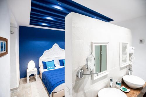 - une chambre bleue avec un lit et un lavabo dans l'établissement Dar Indigo, à Sidi Bou Saïd