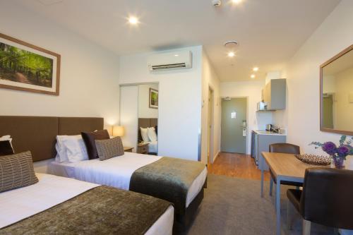 a hotel room with two beds and a table at Wyndham Garden Remarkables Park Queenstown in Queenstown