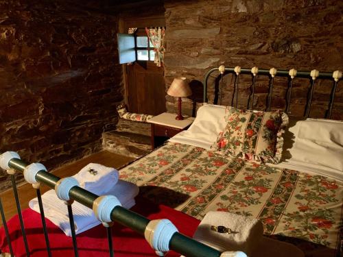 ein Schlafzimmer mit einem Bett in einer Steinmauer in der Unterkunft Casa do Tanque in Lousã