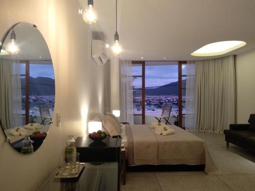 a bedroom with a bed and a mirror and a couch at Orlanova Boutique Hotel in Arraial do Cabo