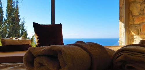 a teddy bear laying on a bed in front of a window at Ashram Villa Sunshine in Sitges