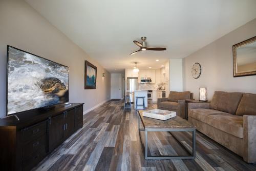 a living room with a couch and a flat screen tv at 126 Hale Kamaole in Wailea