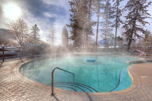 a swimming pool with a fountain in a park at Fairmont Hot Springs Resort in Fairmont Hot Springs